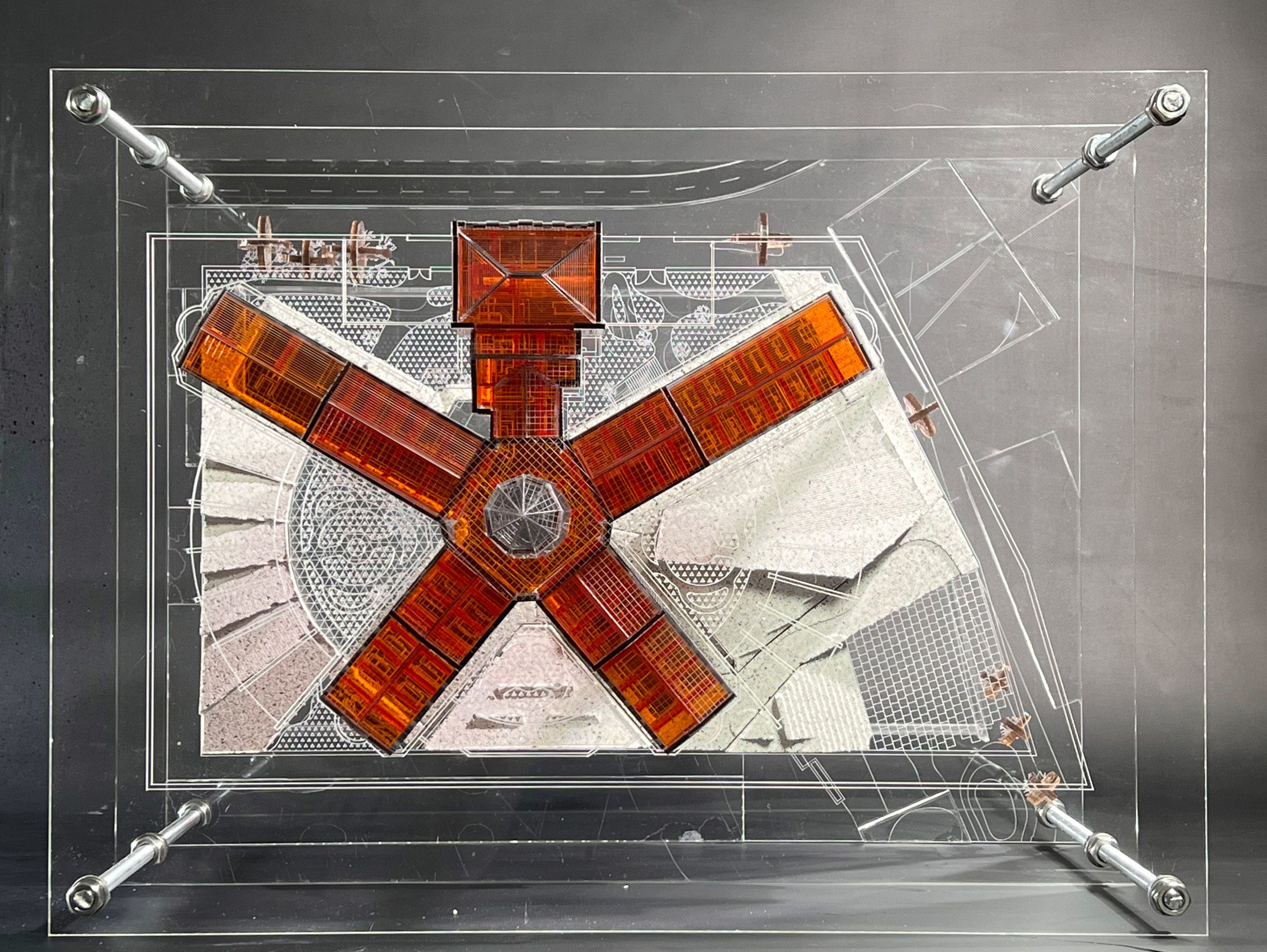 Top view of an orange star-shape architecture model presented on glass slides