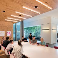 Office meeting space with a large white table and timber ceiling