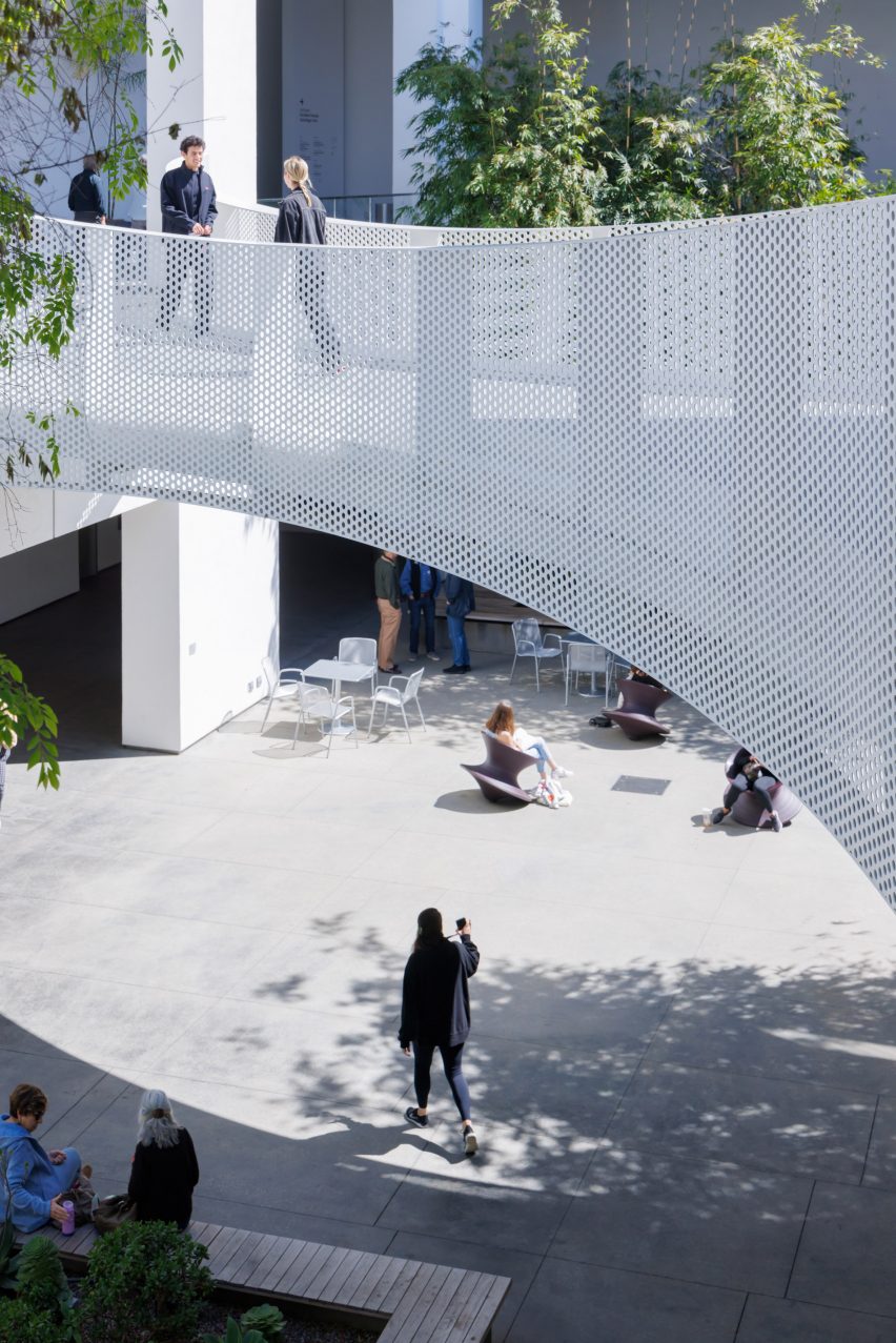 An outdoor courtyard at the Hammer Museum by Michael Maltzan Architects with a white pedestrian bridge