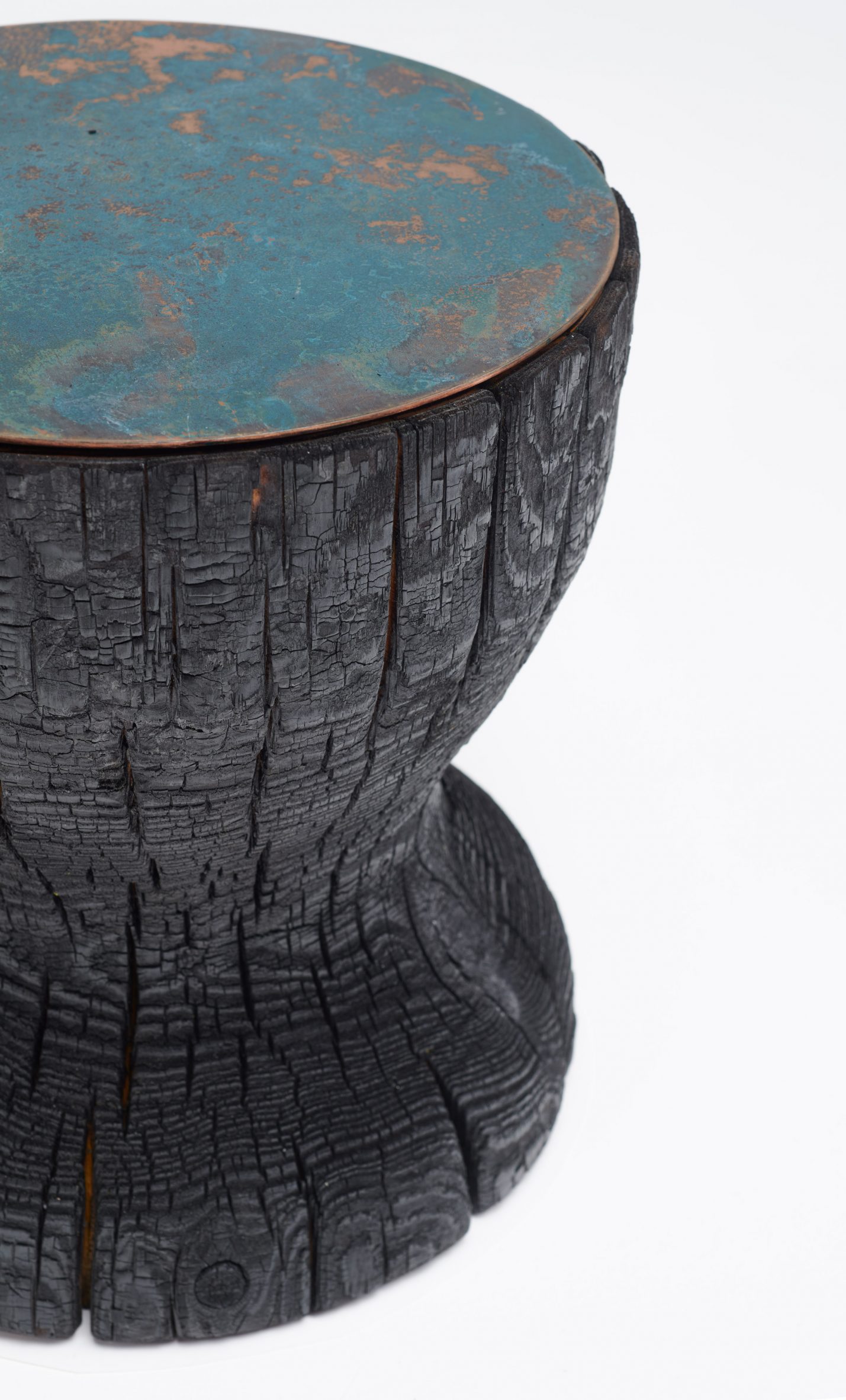 A blackened wood stool with a blue metal top by a New Designers winner