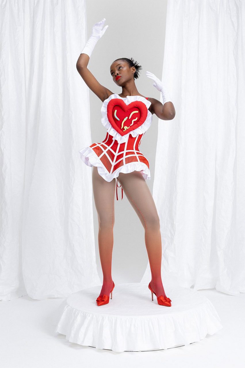 A woman wearing a corset that comprises a red heart with white edging 