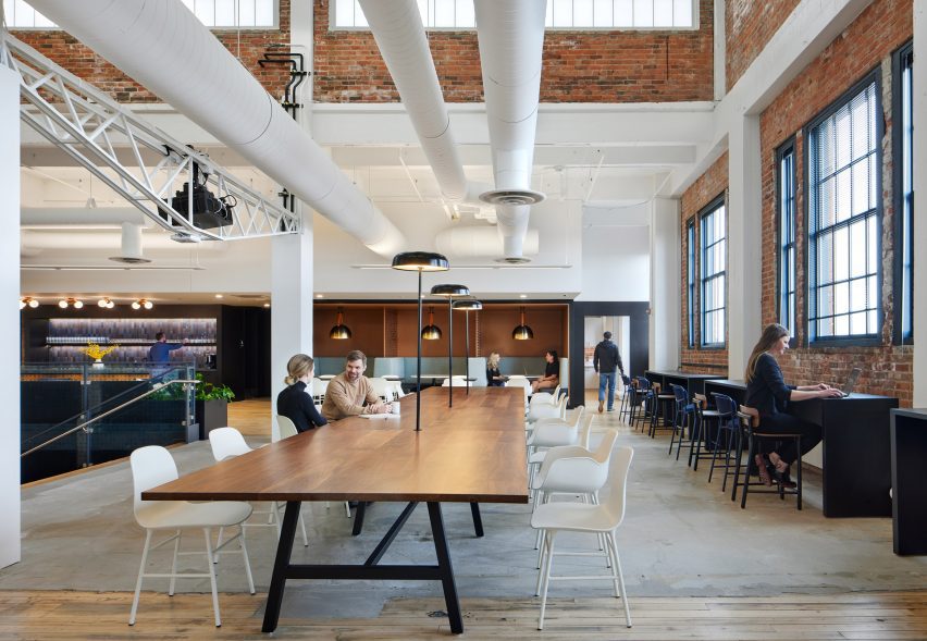 A large wooden communal table in an tall space