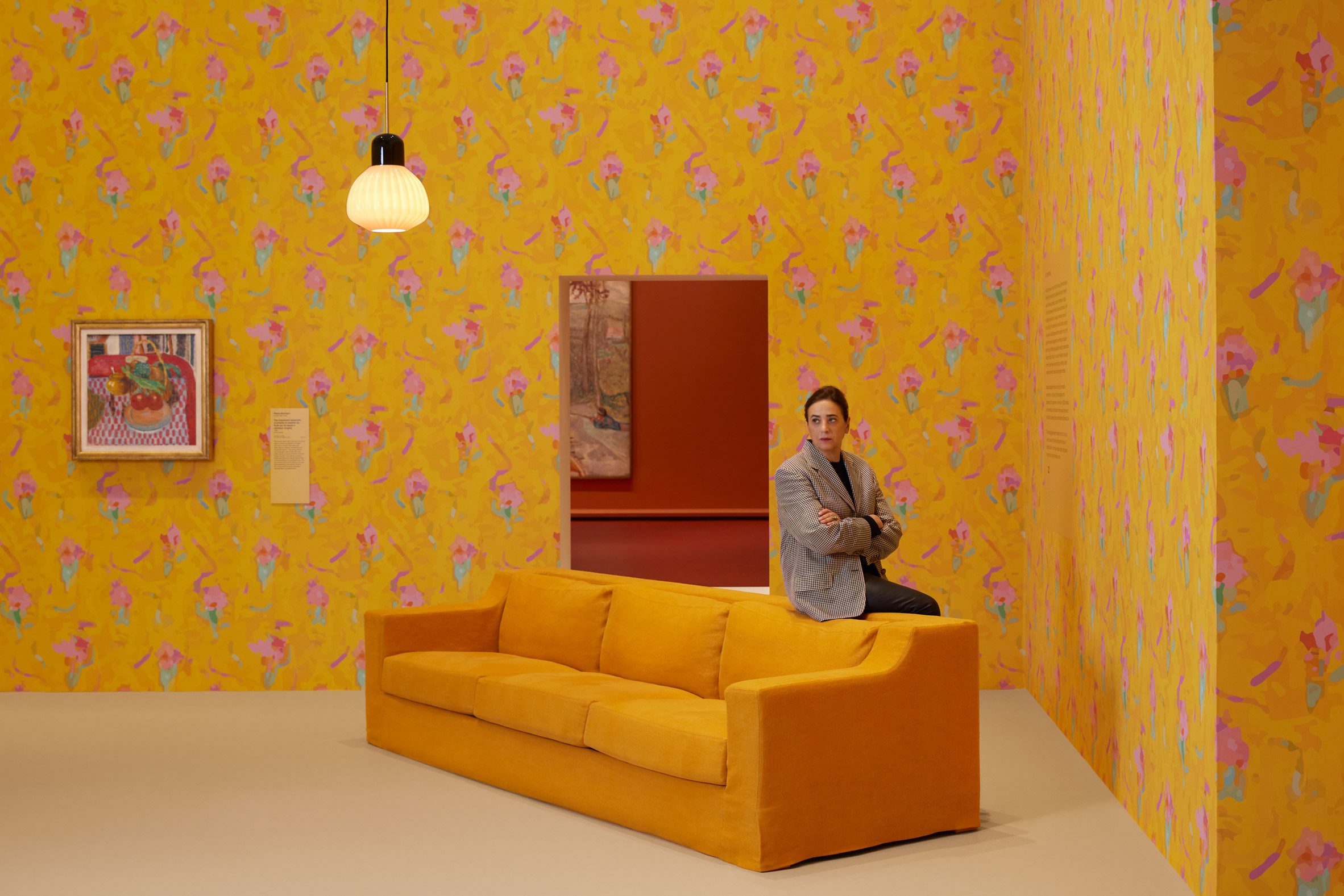 India Mahdavi leaning on a yellow sofa in a yellow gallery