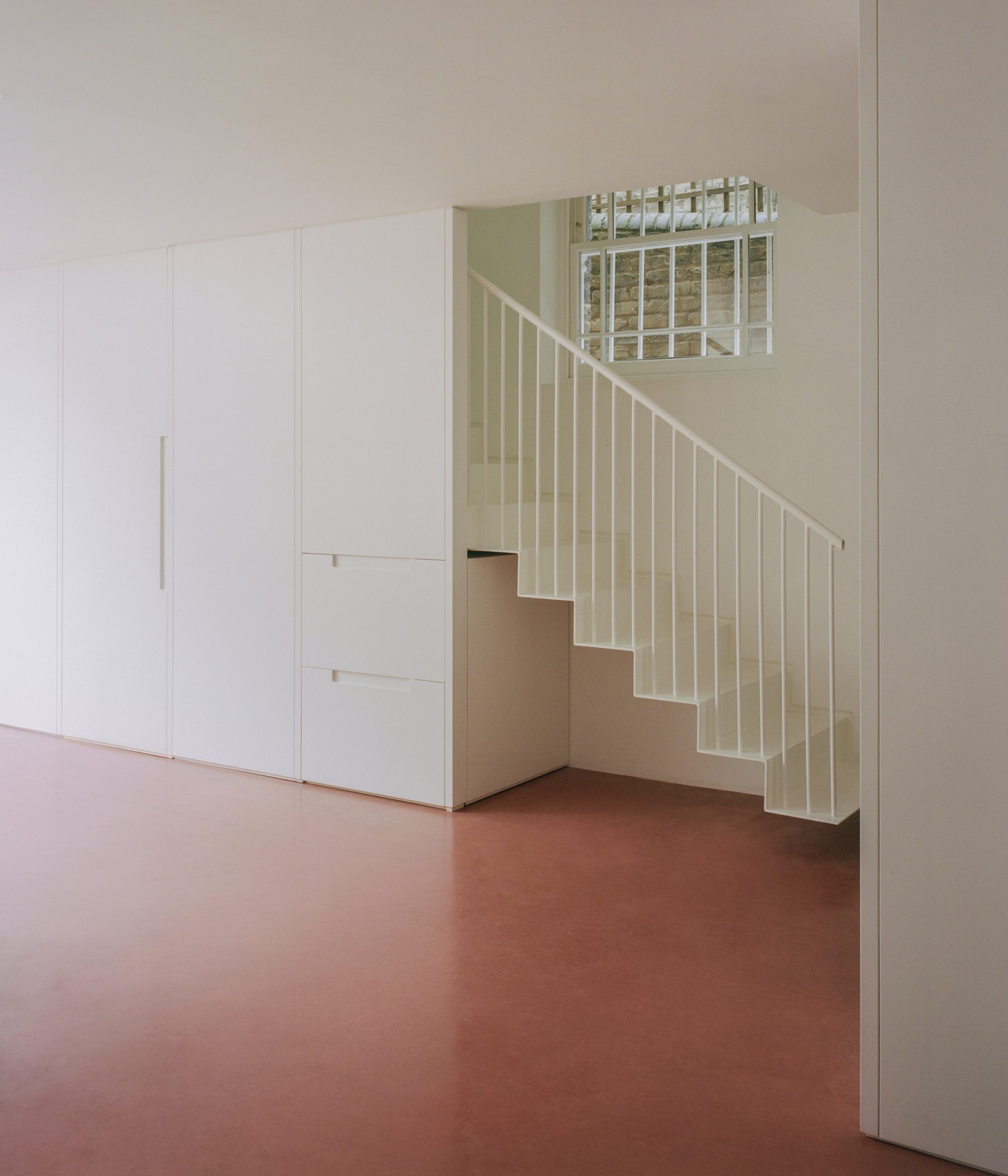 Floating stair over pink-concrete floor