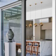 Floor-to-ceiling corner glazing in a room with a marble kitchen island