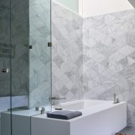 Bathroom with grey geometric wall tiles and a rectangular bath