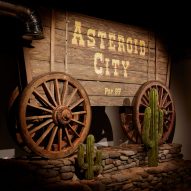 Asteroid City sign on a wooden cowboy-style wagon