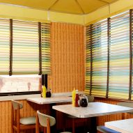 A 1950s-style diner with wooden seating and pastel blinds