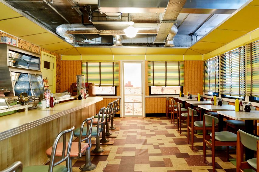 1950s diner film set with square brown floor tiles and steel stools along the service bar