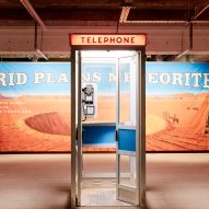 A telephone booth in front of a meteor crater billboard poster