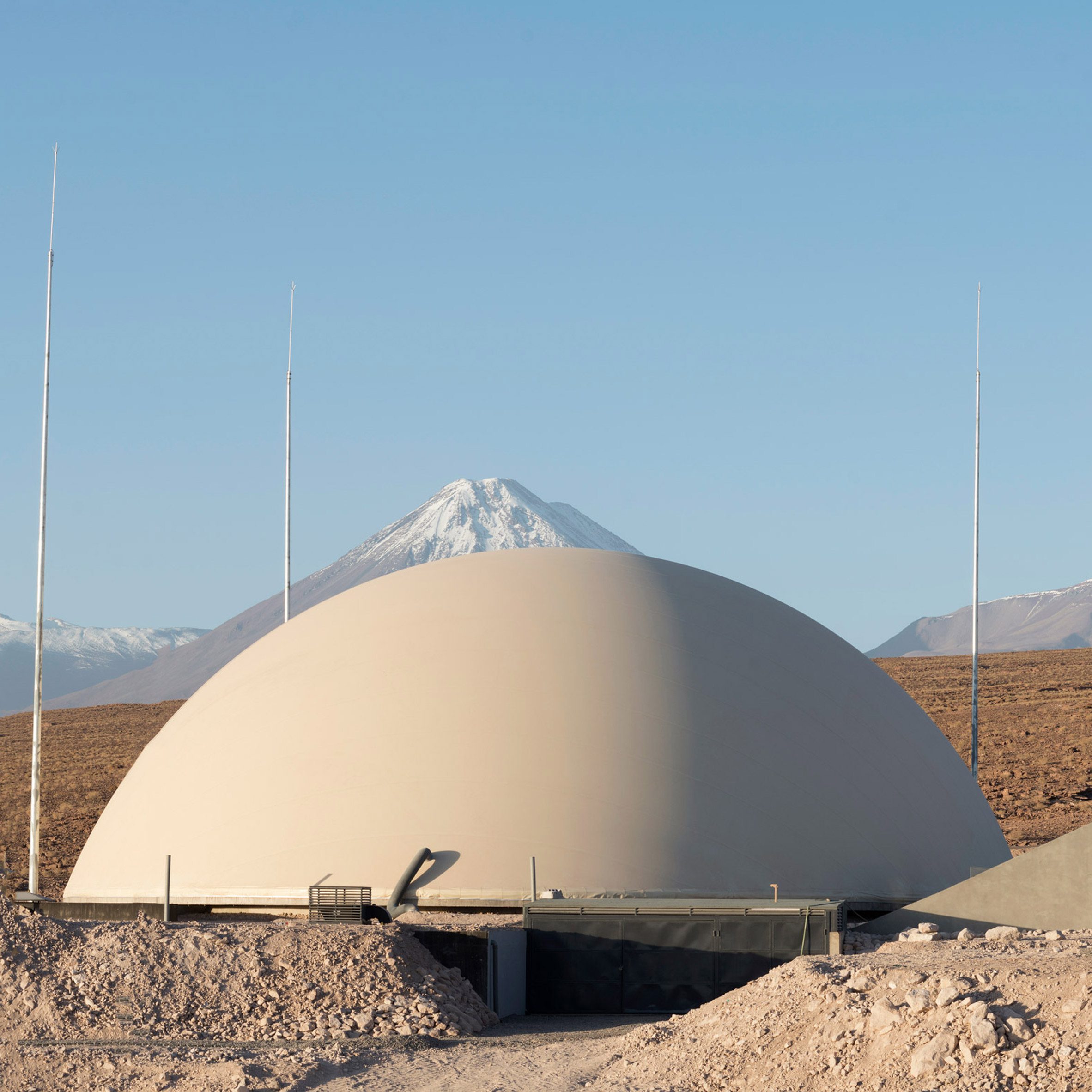 A domed structure in front of the Chilean Andes in the desert