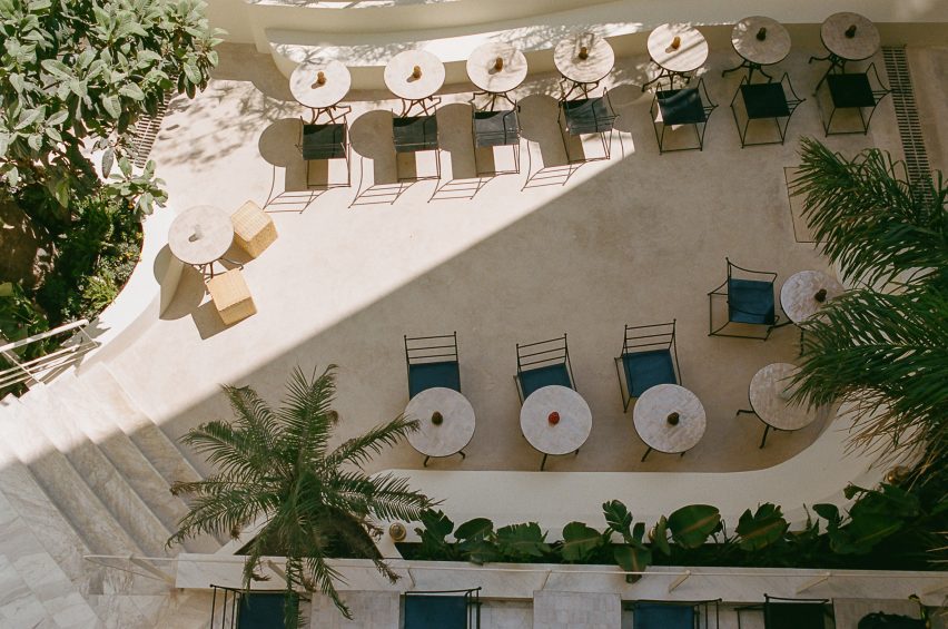 Aerial view of a courtyard with cafe tables and palm trees