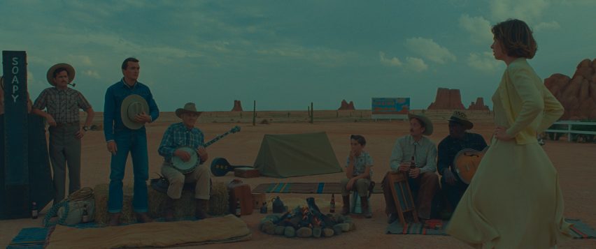 Actors around a campfire on a desert-like set