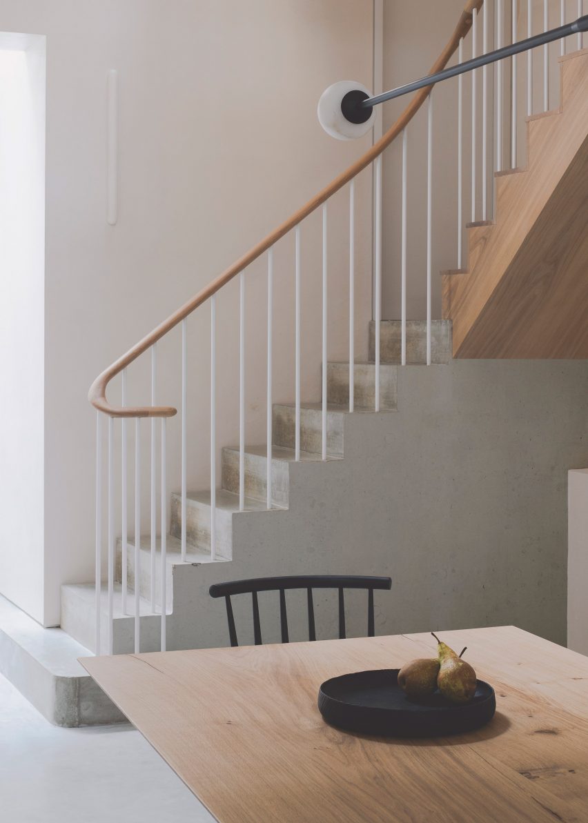Concrete staircase with wooden banister in Chelsea Mews House