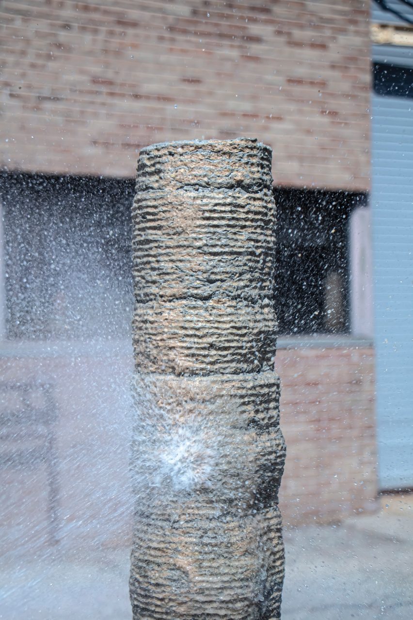 A concrete column getting sprayed with water