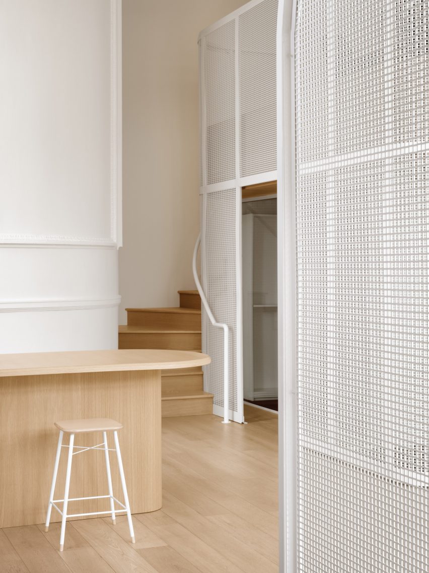 Steel mesh partitions beside an oak staircase and counter