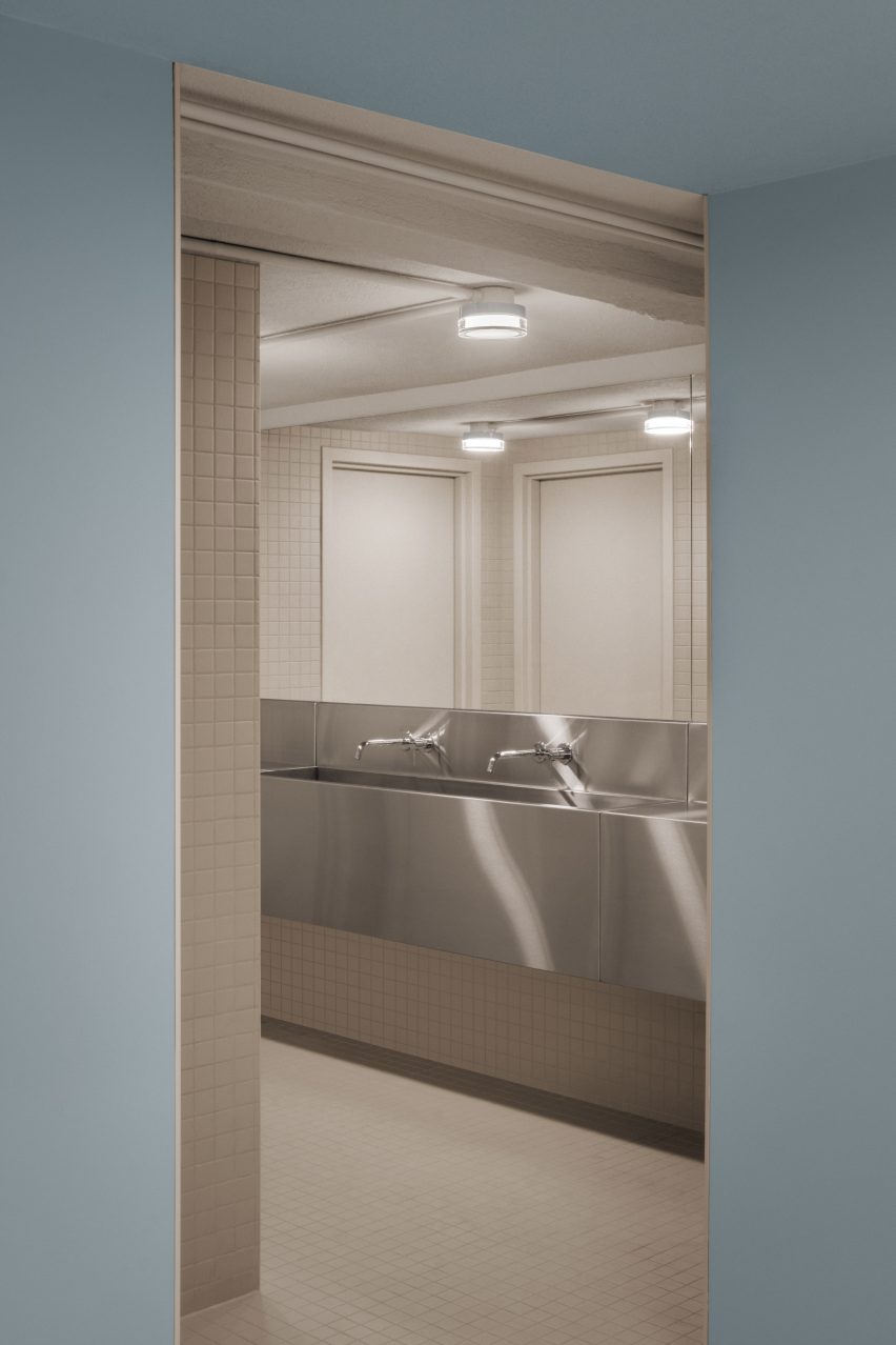 حمام با کاشی های خاکستری که از اتاق آبی مشاهده می شود