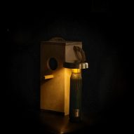 Dark green lamp in darkness beside wooden bird box