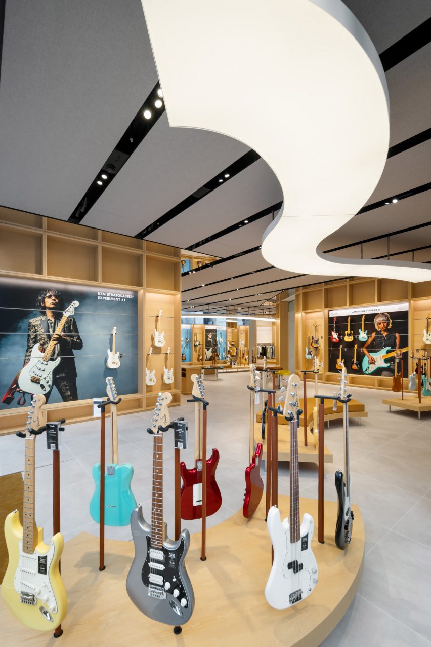 Photo of the first floor of the Fender Tokyo flagship store, showing many guitars displayed on curving light wood display stands