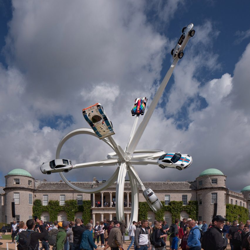 White steel sculpture with cars attached