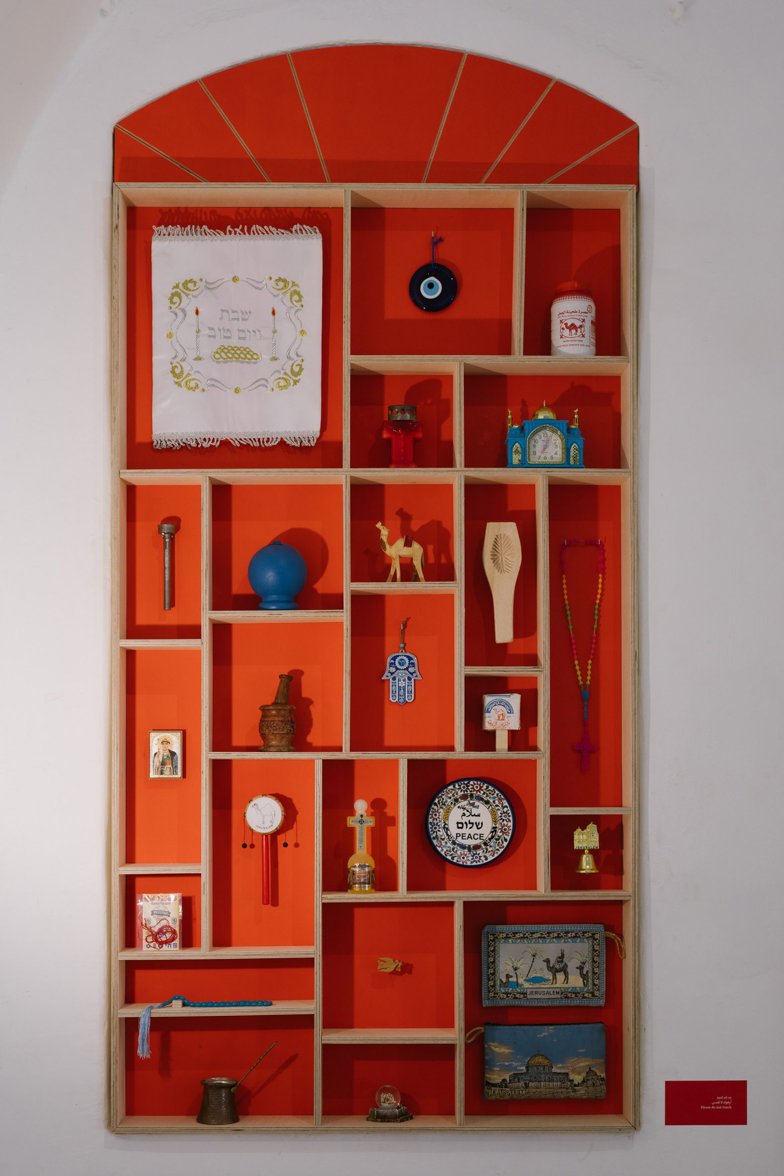 Gridded wooden shelving with traditional Israeli objects displayed