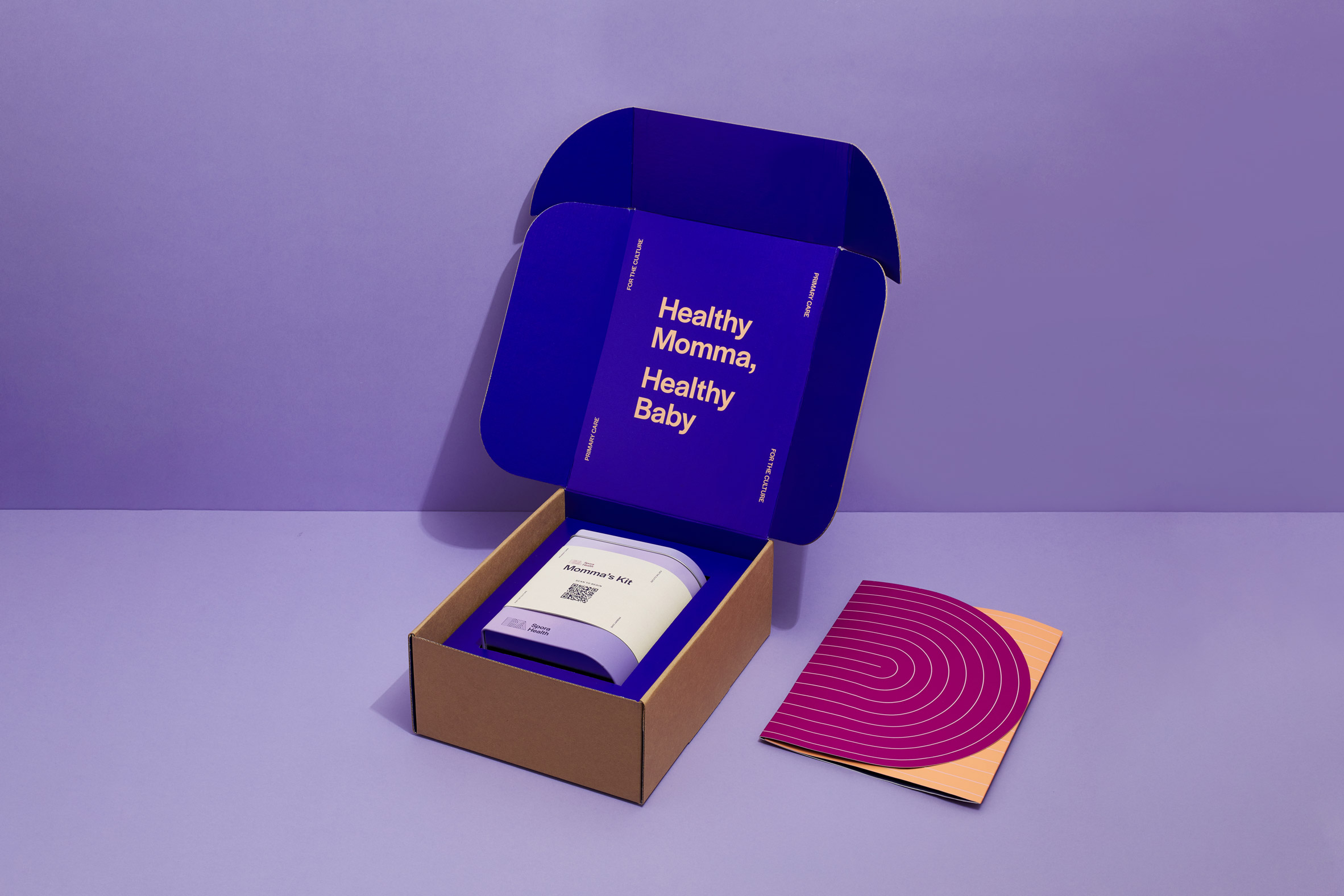Photo of a cardboard box opened at the top to reveal the lavender-coloured Momma's Kit tin. Text printed on the cobalt blue interior of the box reads 'healthy momma, healthy baby'