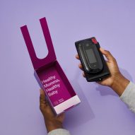 Photo of a person's hands removing a blood pressure cuff from a magenta-coloured box with text on the inside that reads 'healthy momma, healthy baby'