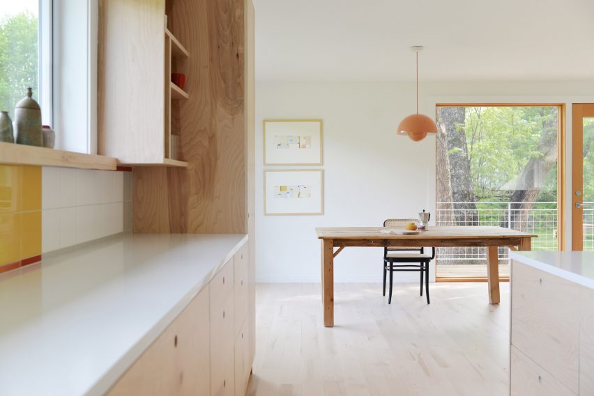 Open-plan kitchen and dining room with wood flooring and wood kitchen units