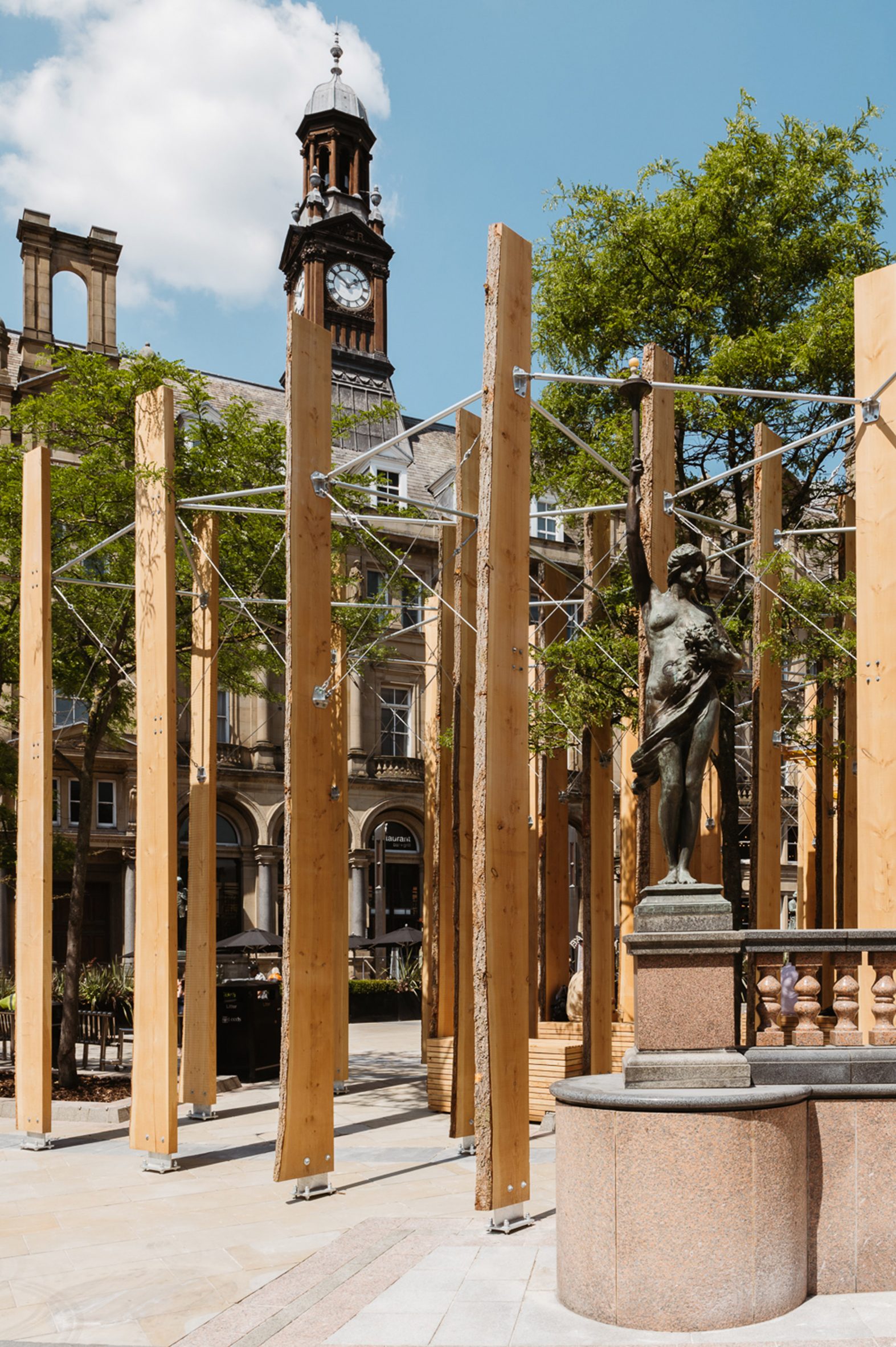 Timber fins standing in Leeds City Square supported by steel rods
