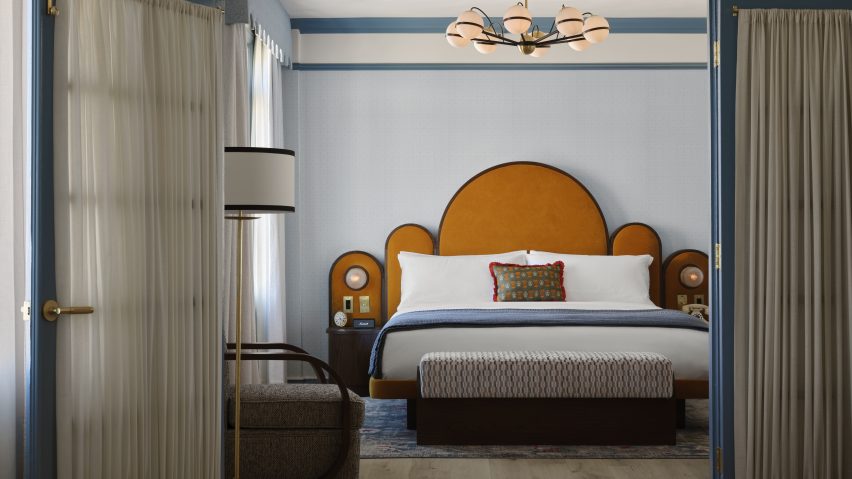 Guest room with dramatic scalloped headboard behind bed