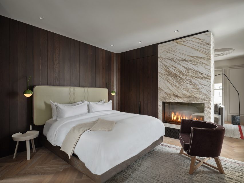 Bedroom with dark wood panelling and large marbled fireplace
