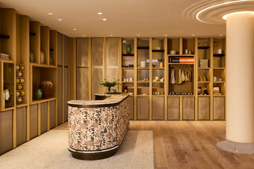 Hotel lobby with wood shelving and floral-wrapped reception desk