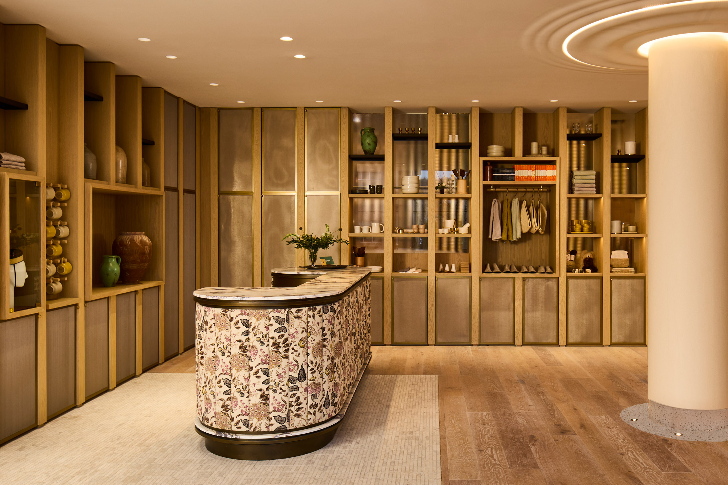 Hotel lobby with wood shelving and floral-wrapped reception desk