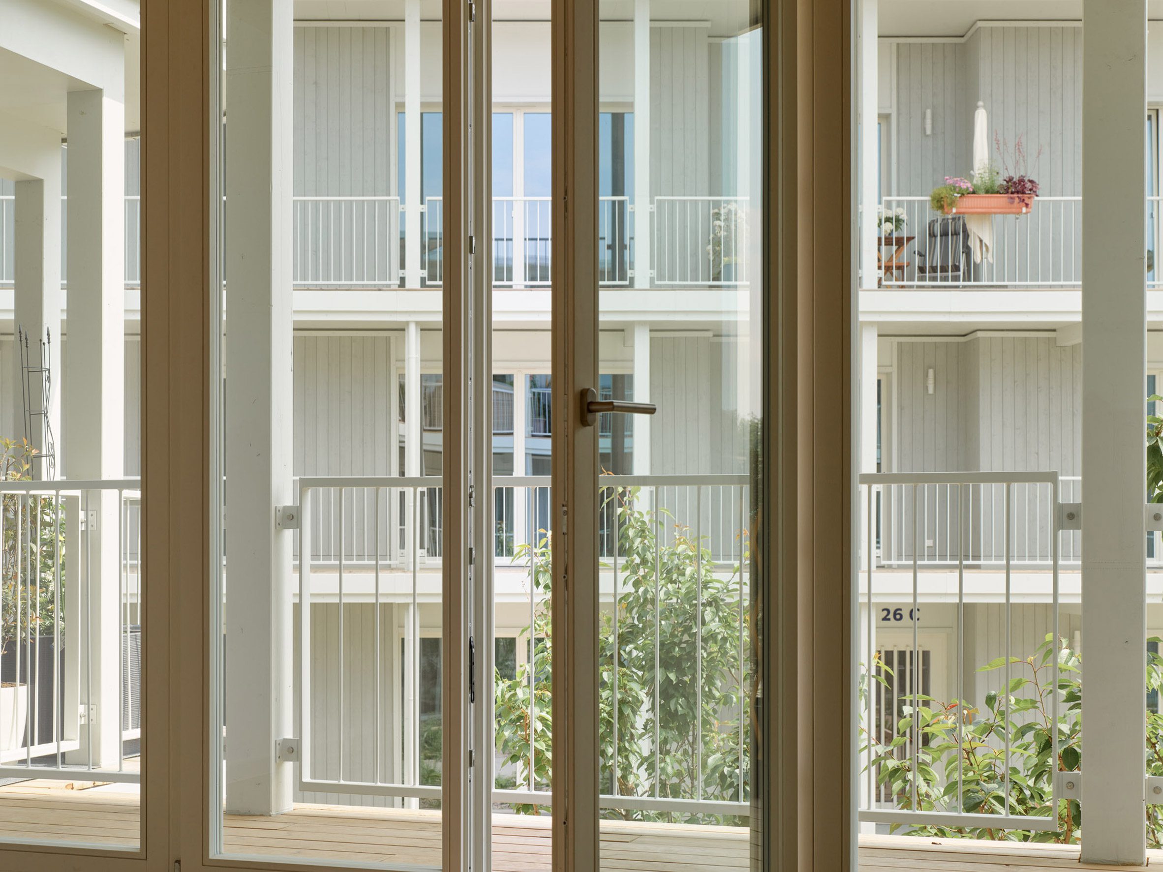 Glass doors opening onto a covered walkway in a multi-generational housing project