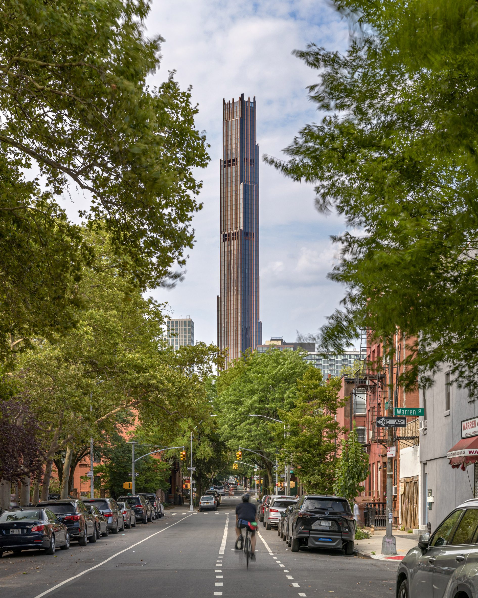 Brooklyn Tower rising from between trees on Dekalb Street in Brooklyn