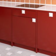 Red kitchen units with terracotta wall tiles
