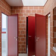 Three red doors open in a terracotta brick entryway