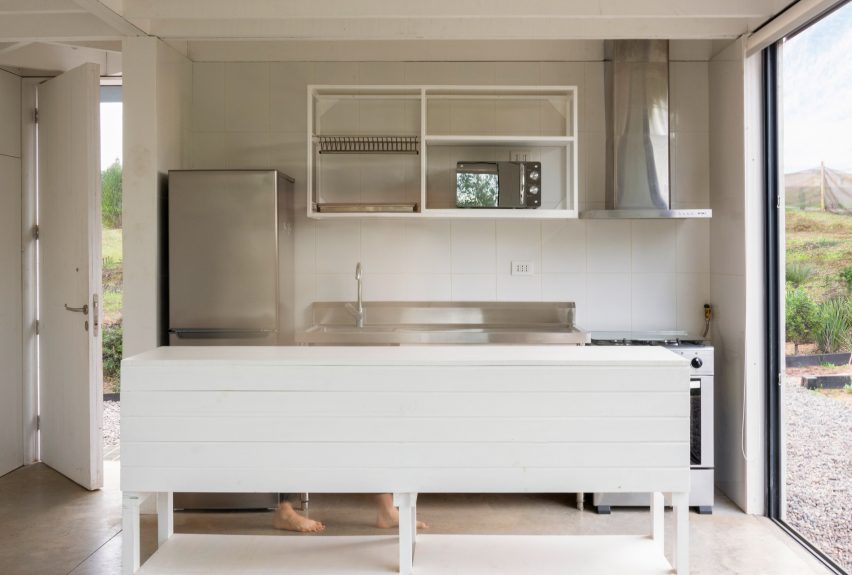 Cocina blanca sencilla con electrodomésticos de acero inoxidable