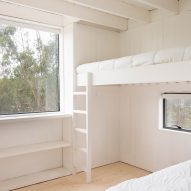 A bedroom with a bunk bed and large window