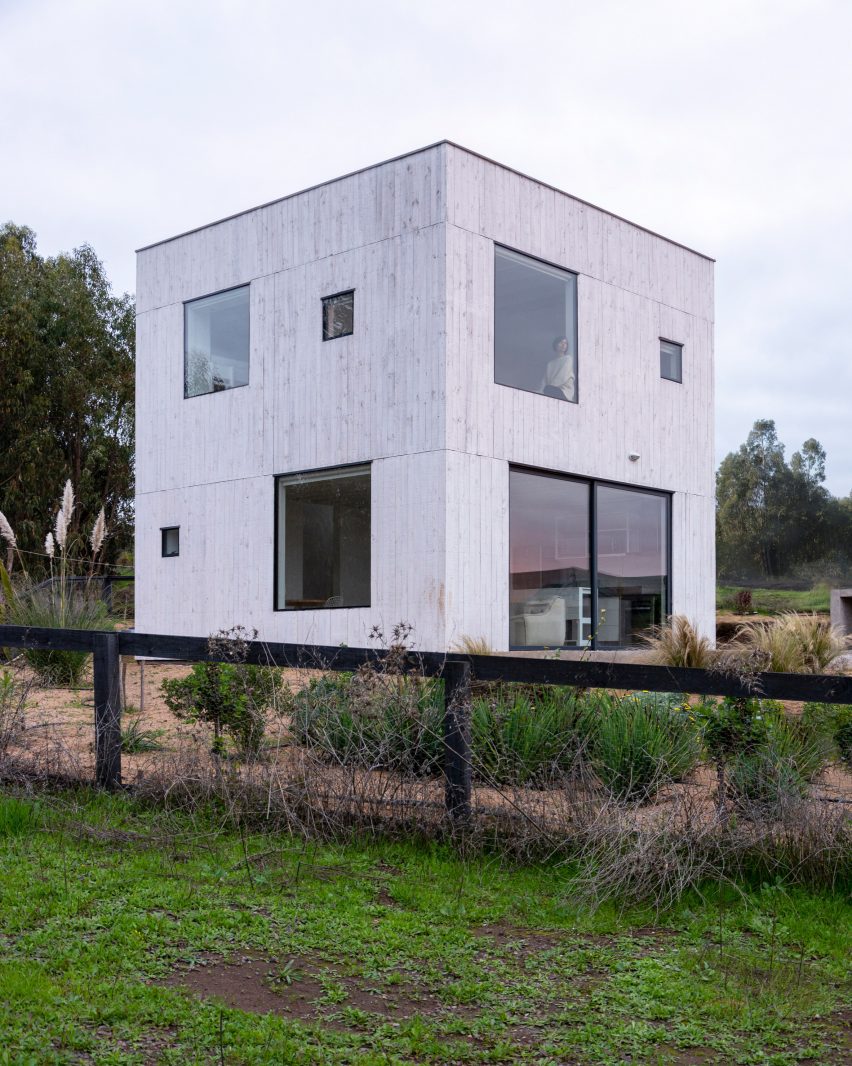 Una casa en forma de cubo con ventanas cuadradas.