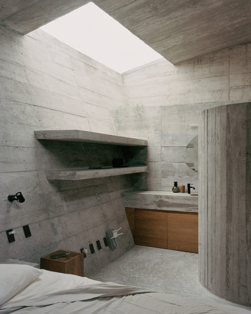 A bathroom and bedroom that features a large skylight