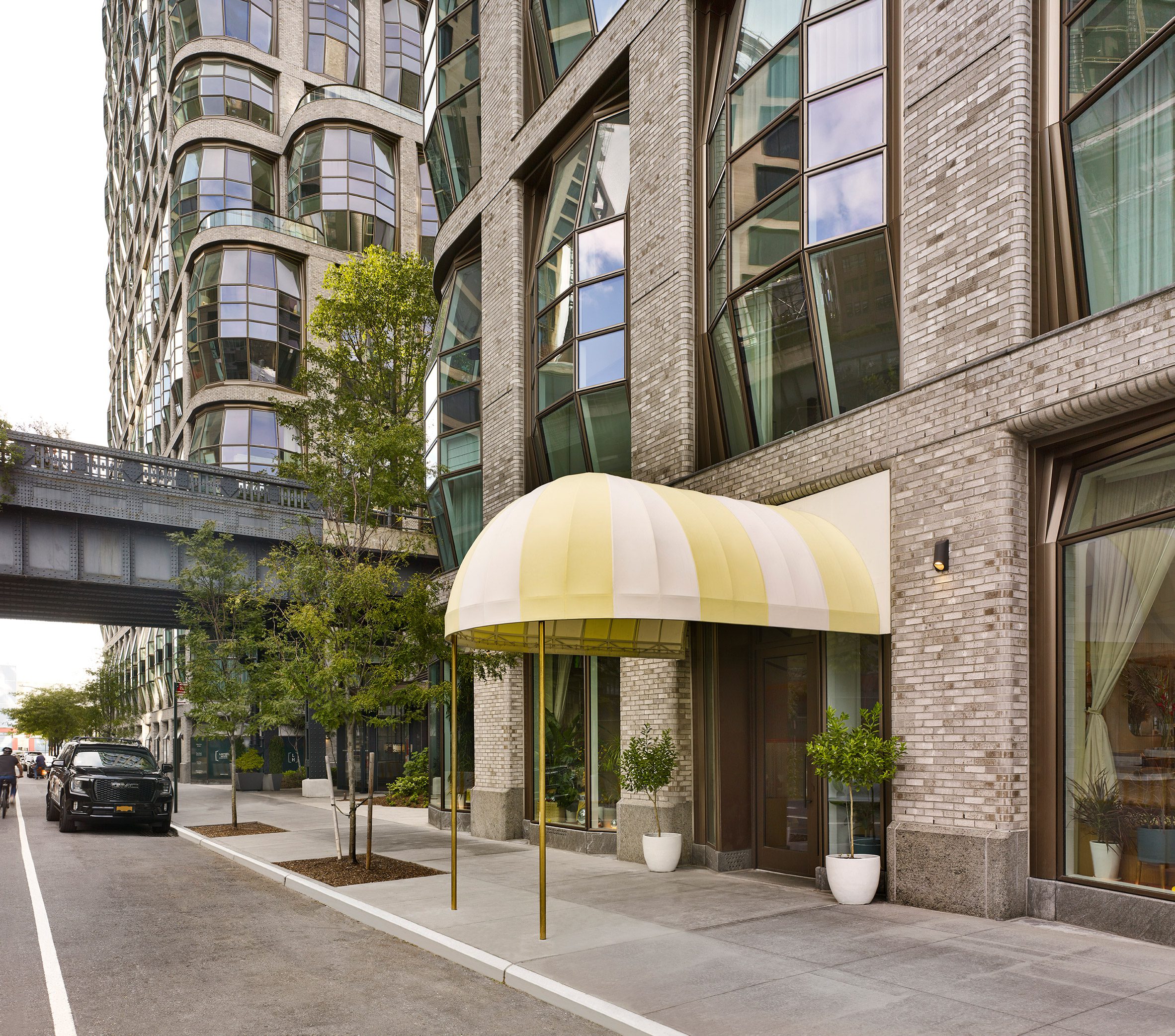 Exterior view of Thomas Heatherwick's Lantern House building, with a white and yellow striped awning