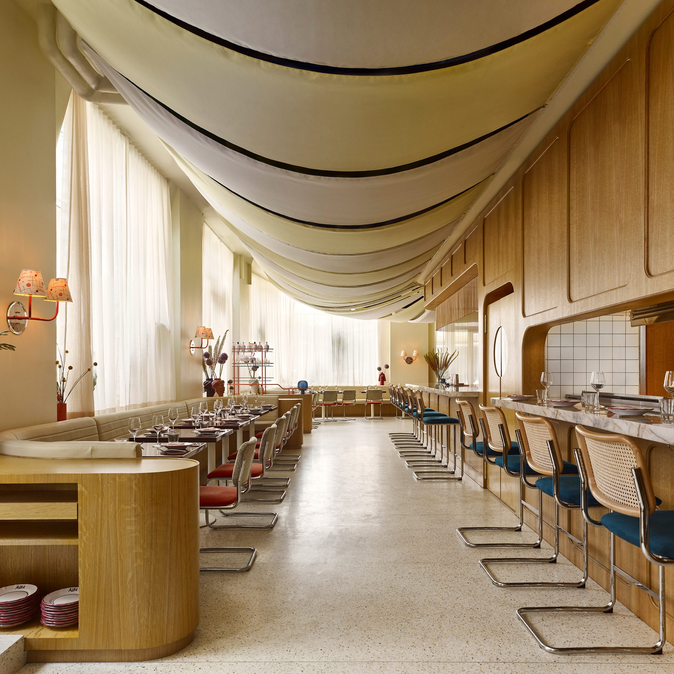 Bright restaurant with seating on two sides and fabric panels overhead
