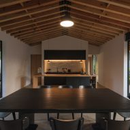 Open-plan kitchen and dining room with a black wooden table and kitchen island