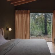Bedroom with dark timber walls and sheer linen curtains