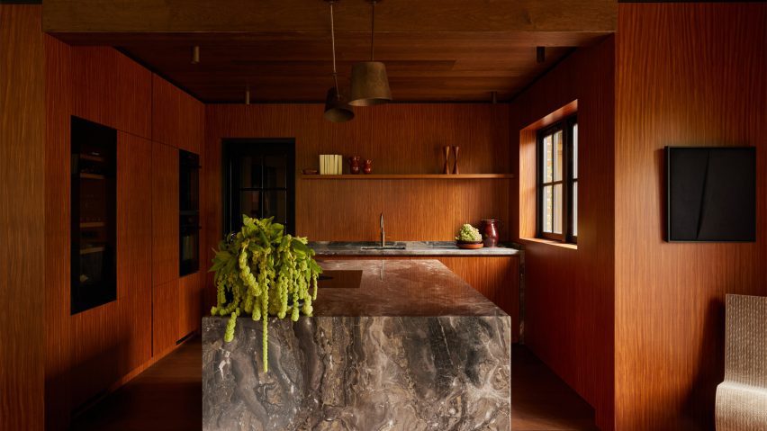 Kitchen interior by DAB Studio with timber walls and a marble kitchen island
