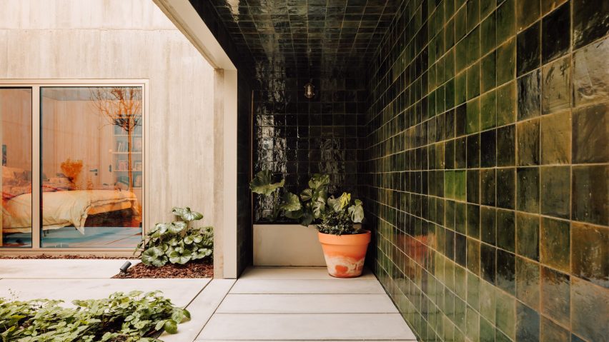 Covered walkway in a residential patio decorated in green tiles