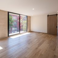 Interior space with white walls, wood flooring and glass sliding double doors