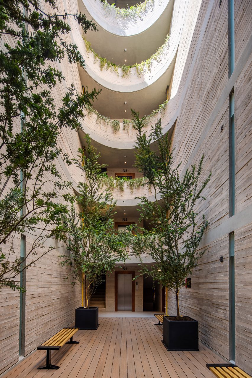 Concrete courtyard with curved balconies and greenery