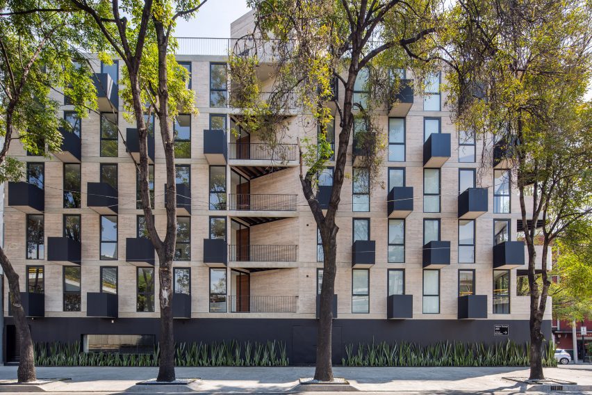 Multi-storey concrete housing by HGR Arquitectos on a tree-lined street
